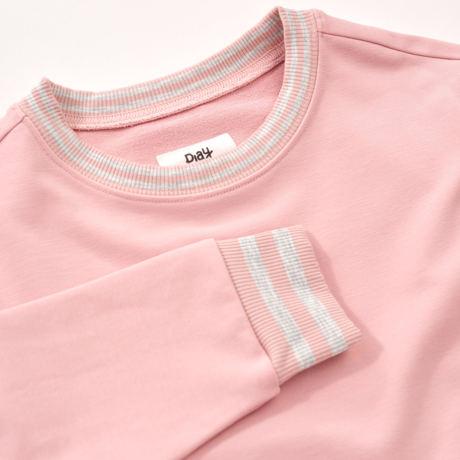 Close up flat lay image of the collar and sleeve detail on the Mauve Blush Pocket Crewneck