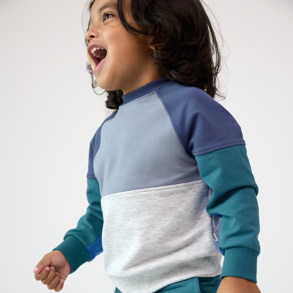 Close up side view image of smiling boy wearing the Windy Sky Panel Crewneck