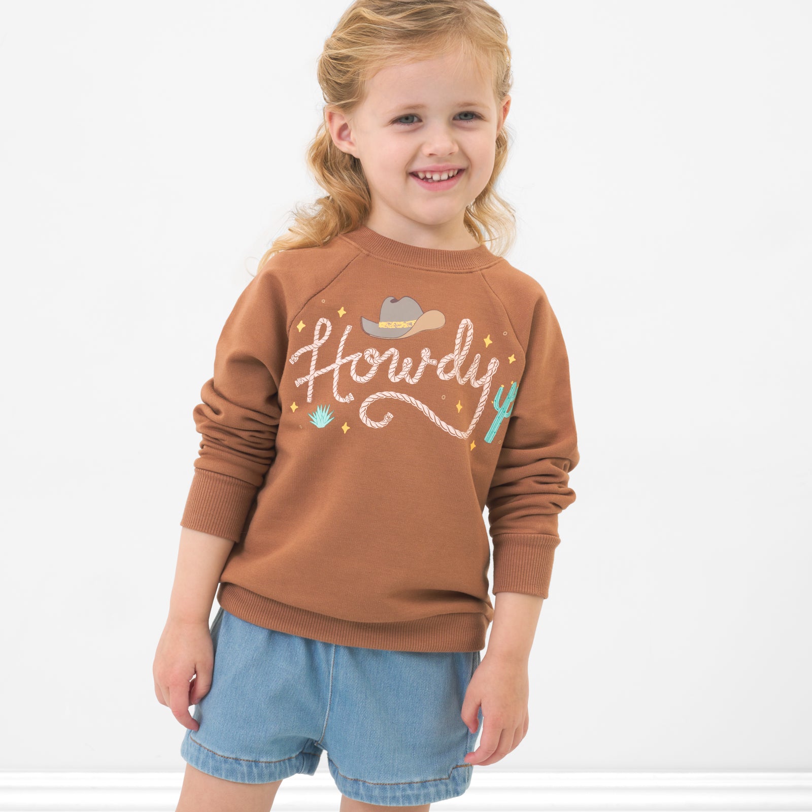 Child wearing a Howdy crewneck sweatshirt