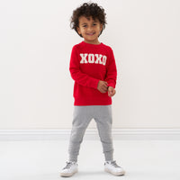 Child wearing a Candy Red crewneck sweatshirt and coordinating jogger