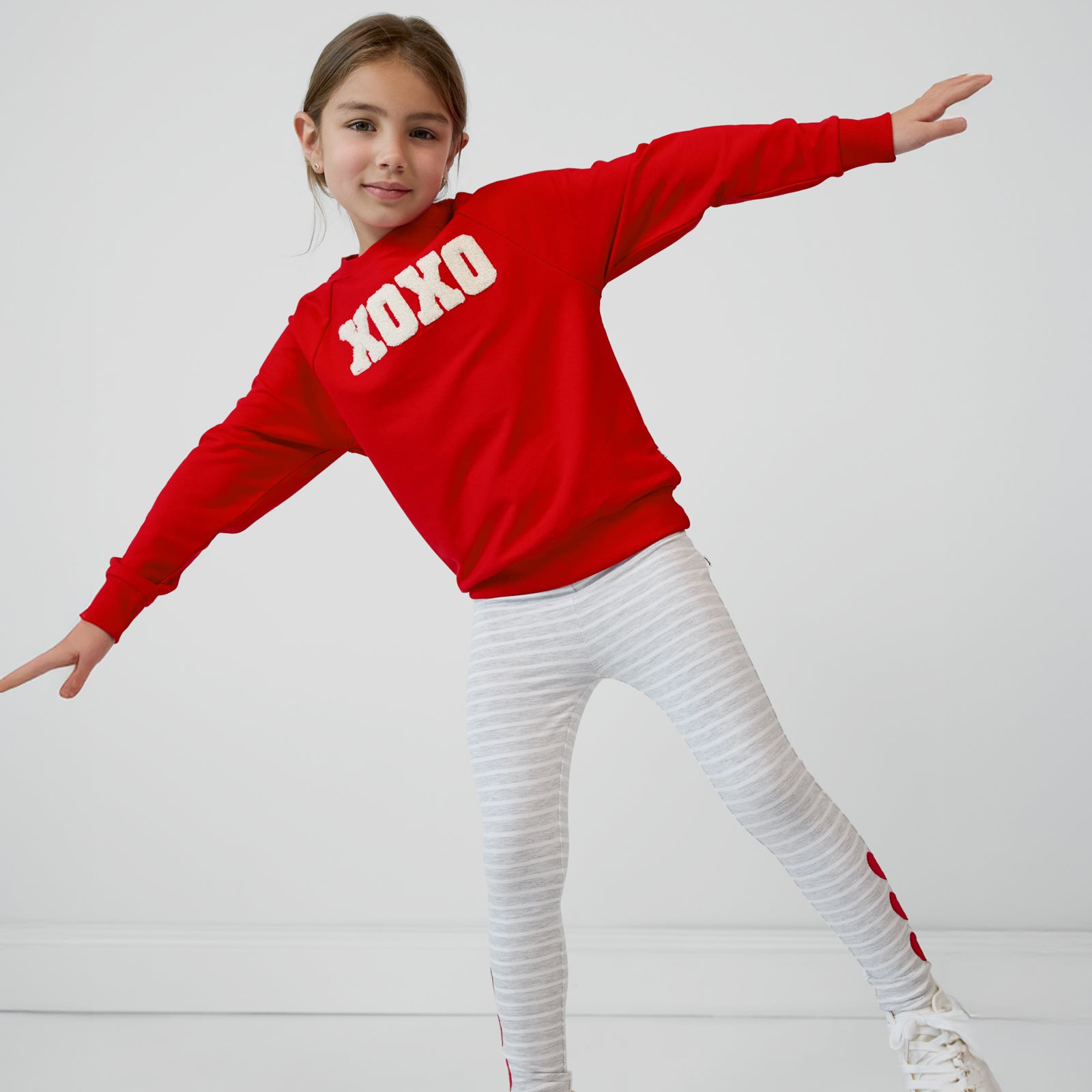 Child wearing an XOXO Crewneck Sweatshirt and coordinating legging