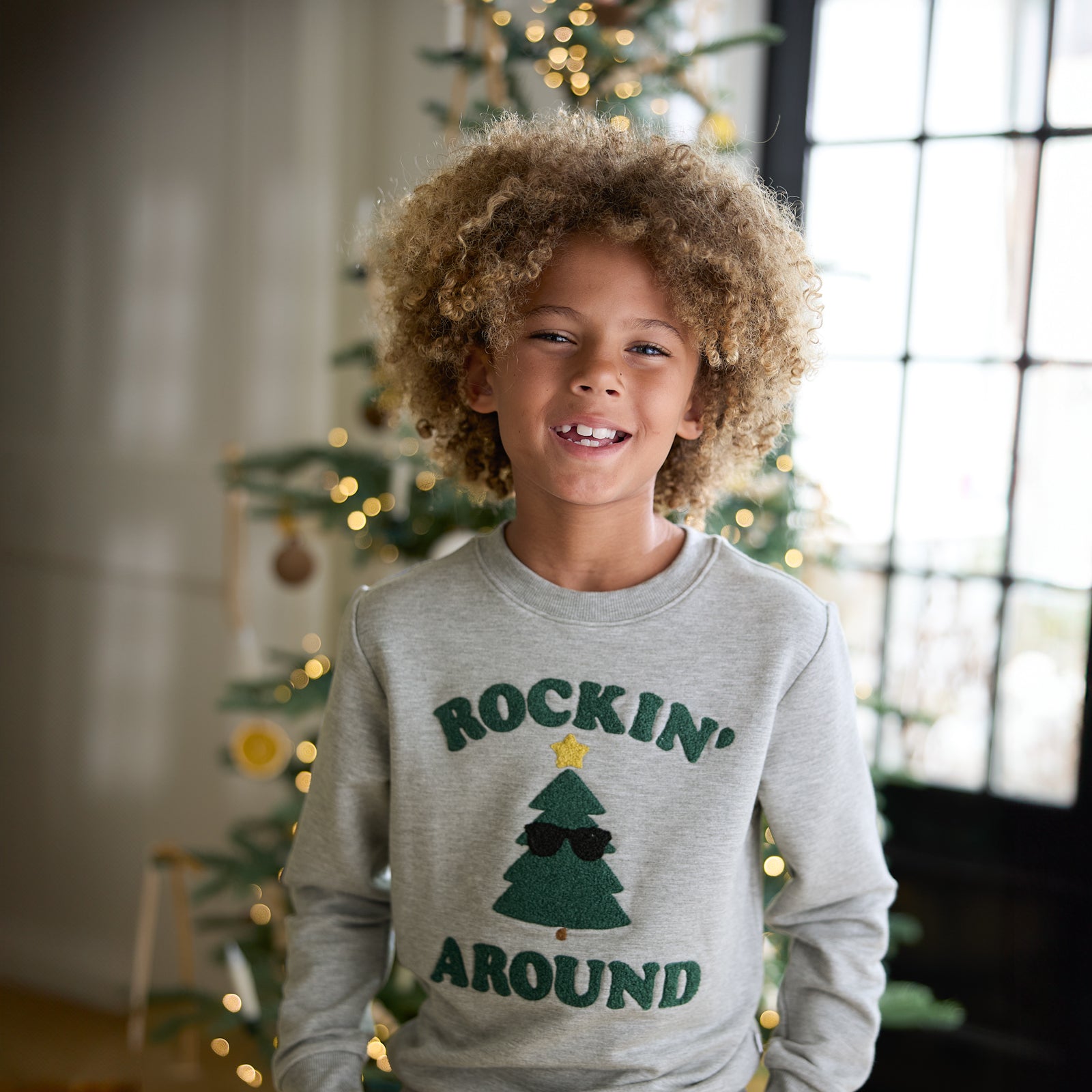 Close up image of a child wearing a Rockin' Around Crewneck Sweatshirt