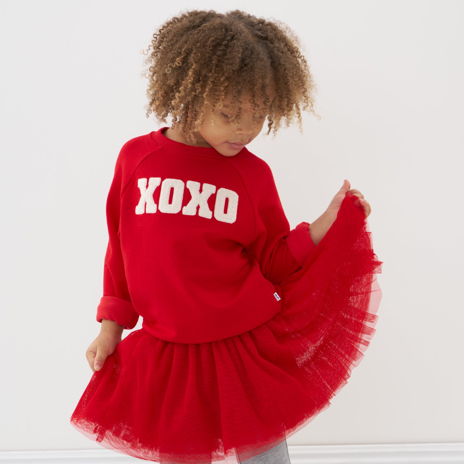 Child wearing an XOXO Crewneck Sweatshirt and matching tutu skirt