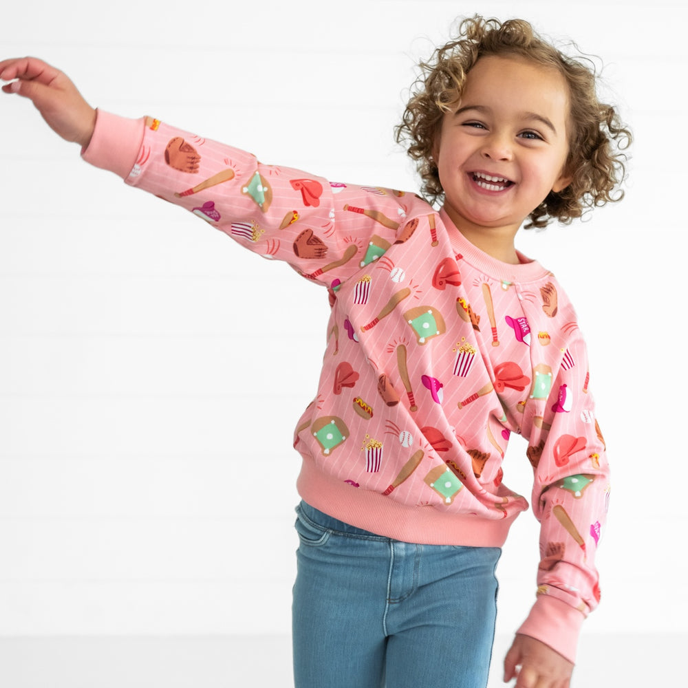 Image of a child wearing a Pink All Stars Crewneck Sweatshirt and Light Blue Denim Jegging