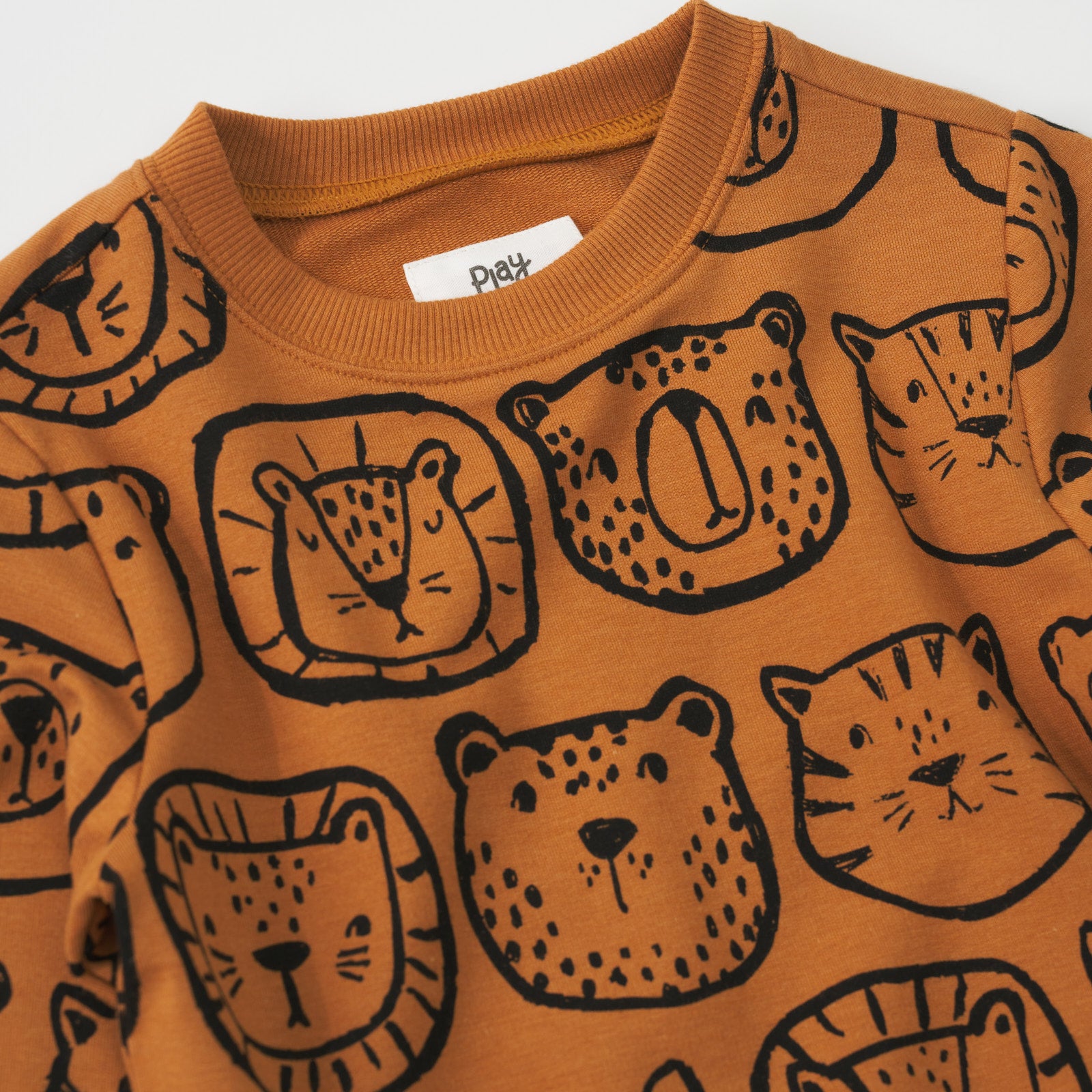 Close-up view of the neckline of an Amber Lions, Tigers & Bears crewneck sweatshirt with black animal illustrations