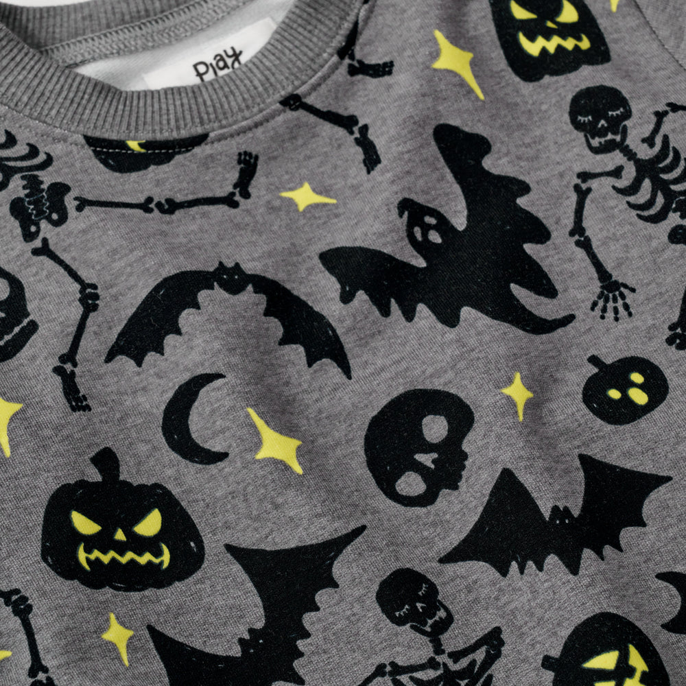 Close up flat lay image of the collar and graphic detail on the Gray Glowing Ghouls Crewneck Sweatshirt