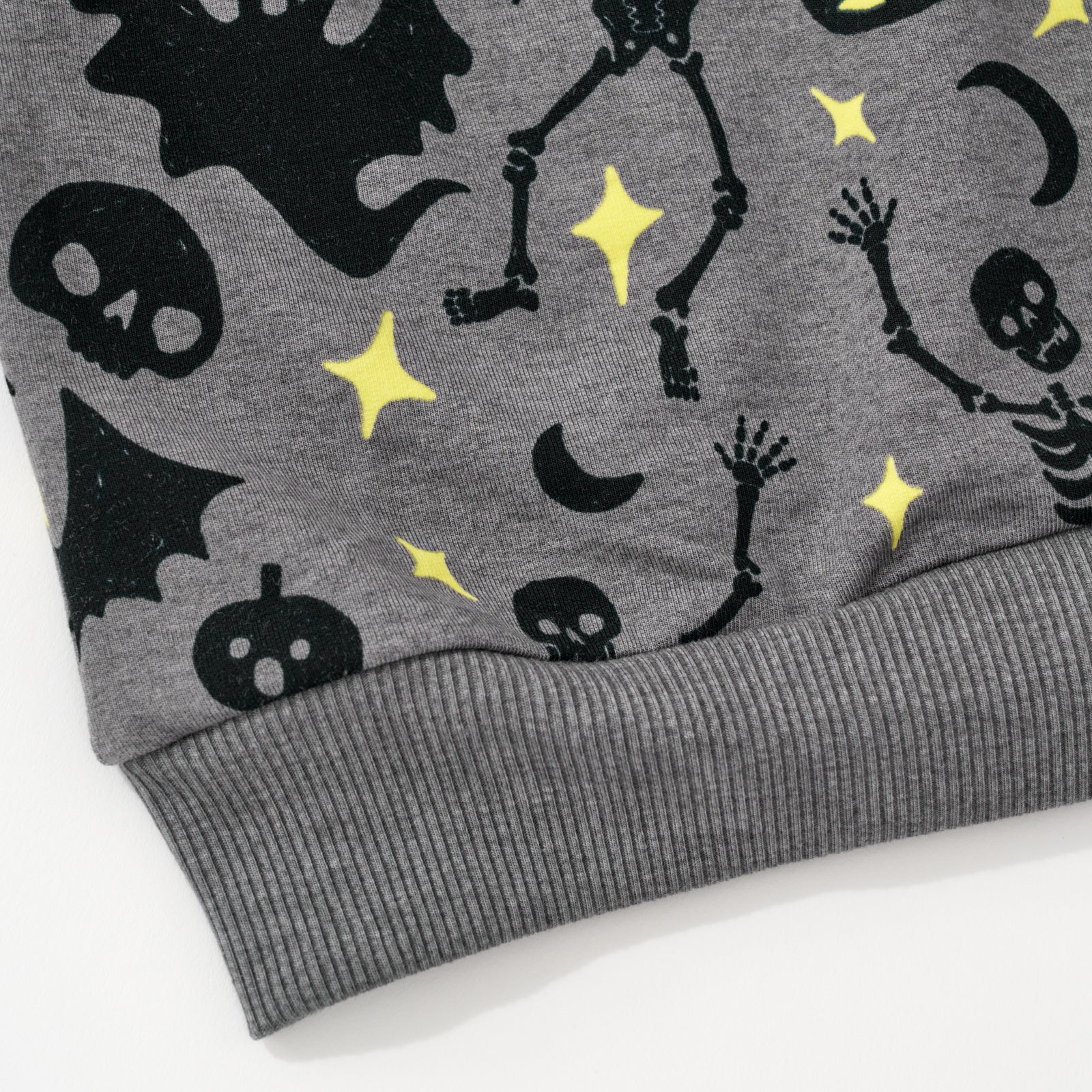 Close up flat lay image of he waist detail on the Gray Glowing Ghouls Crewneck Sweatshirt