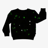 Flatlay showing glow in the dark details on the Glowing Ghouls crewneck