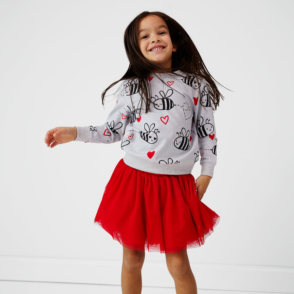 child wearing a bee mine crewneck sweatshirt and candy red tutu skirt