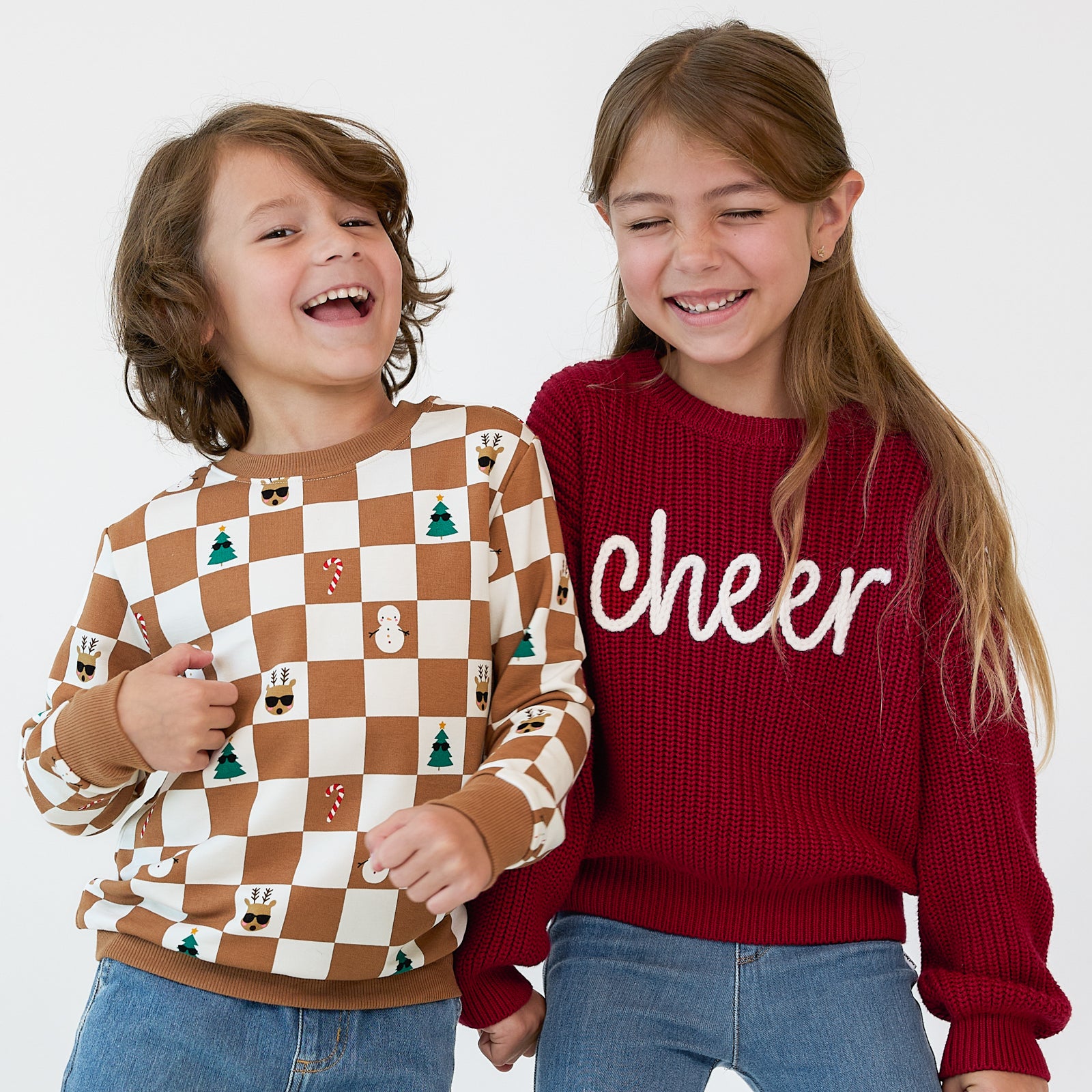 Close up image of two children wearing Holiday Play crewnecks