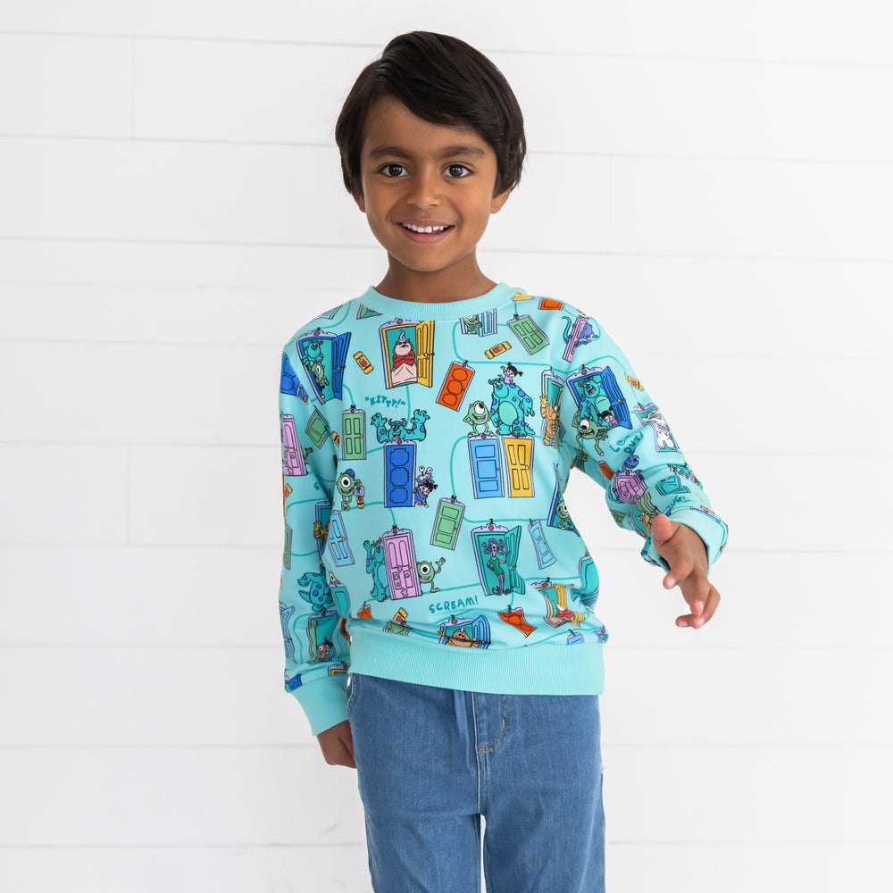 Close up image of smiling boy wearing the Disney Monsters, Inc. Scream Team Crewneck Sweatshirt