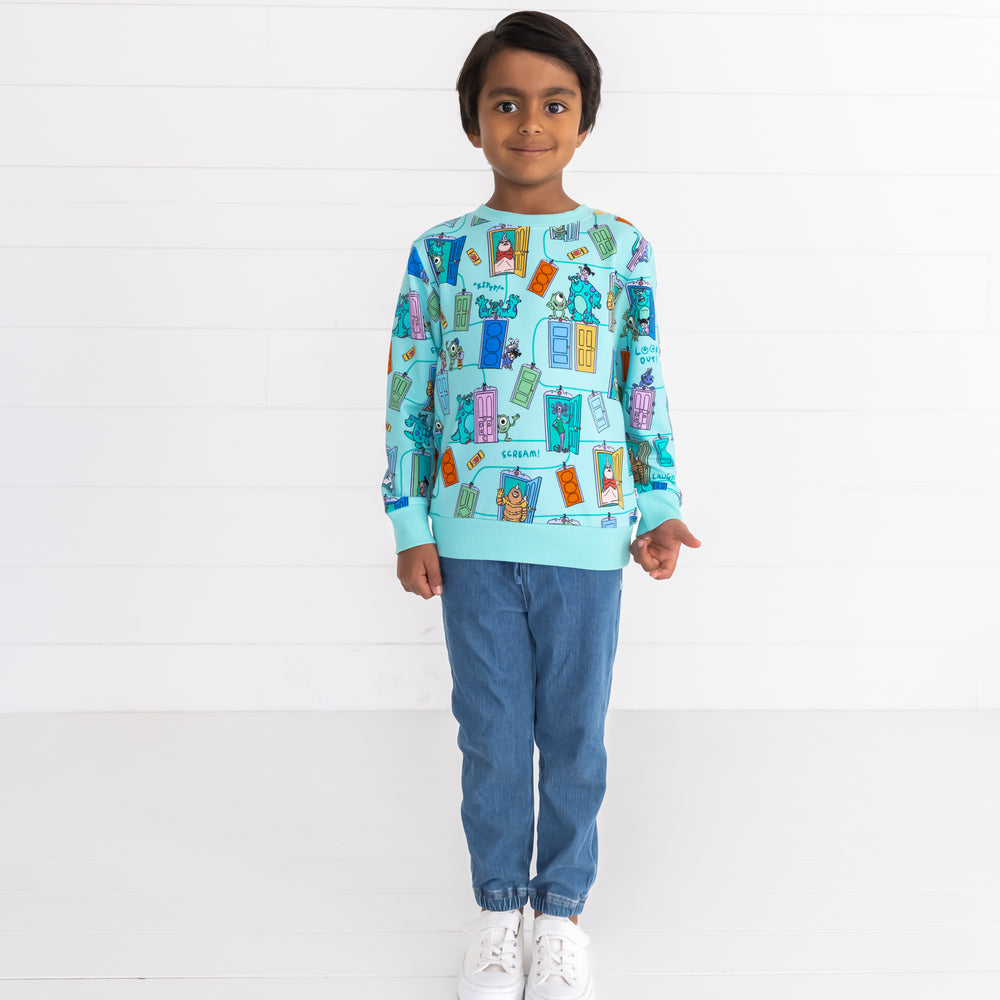 Smiling boy wearing the Disney Monsters, Inc. Scream Team Crewneck Sweatshirt and Midwash Play Joggers