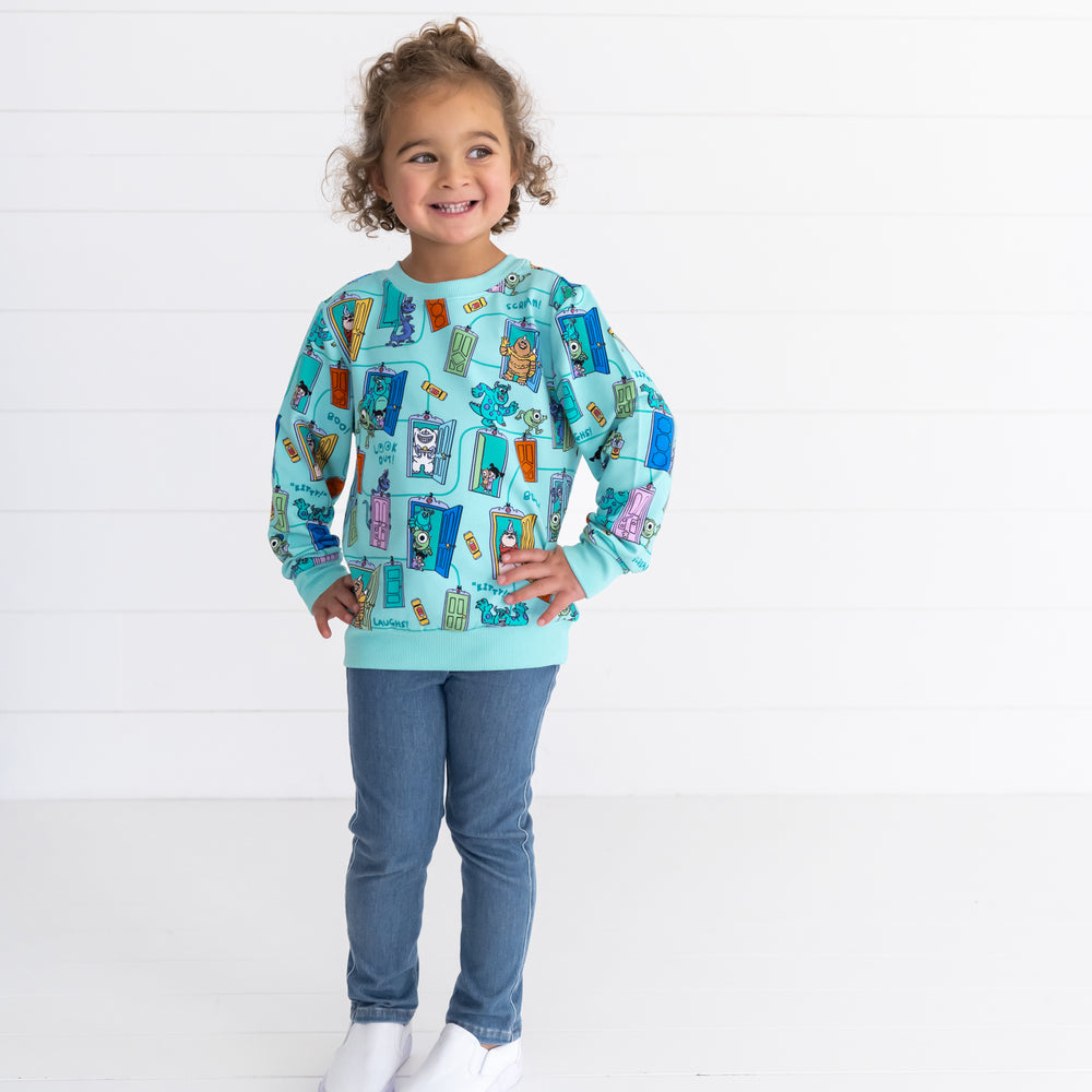 Smiling girl wearing the Disney Monsters, Inc. Scream Team Crewneck Sweatshirt and Midwash Play Jeggings