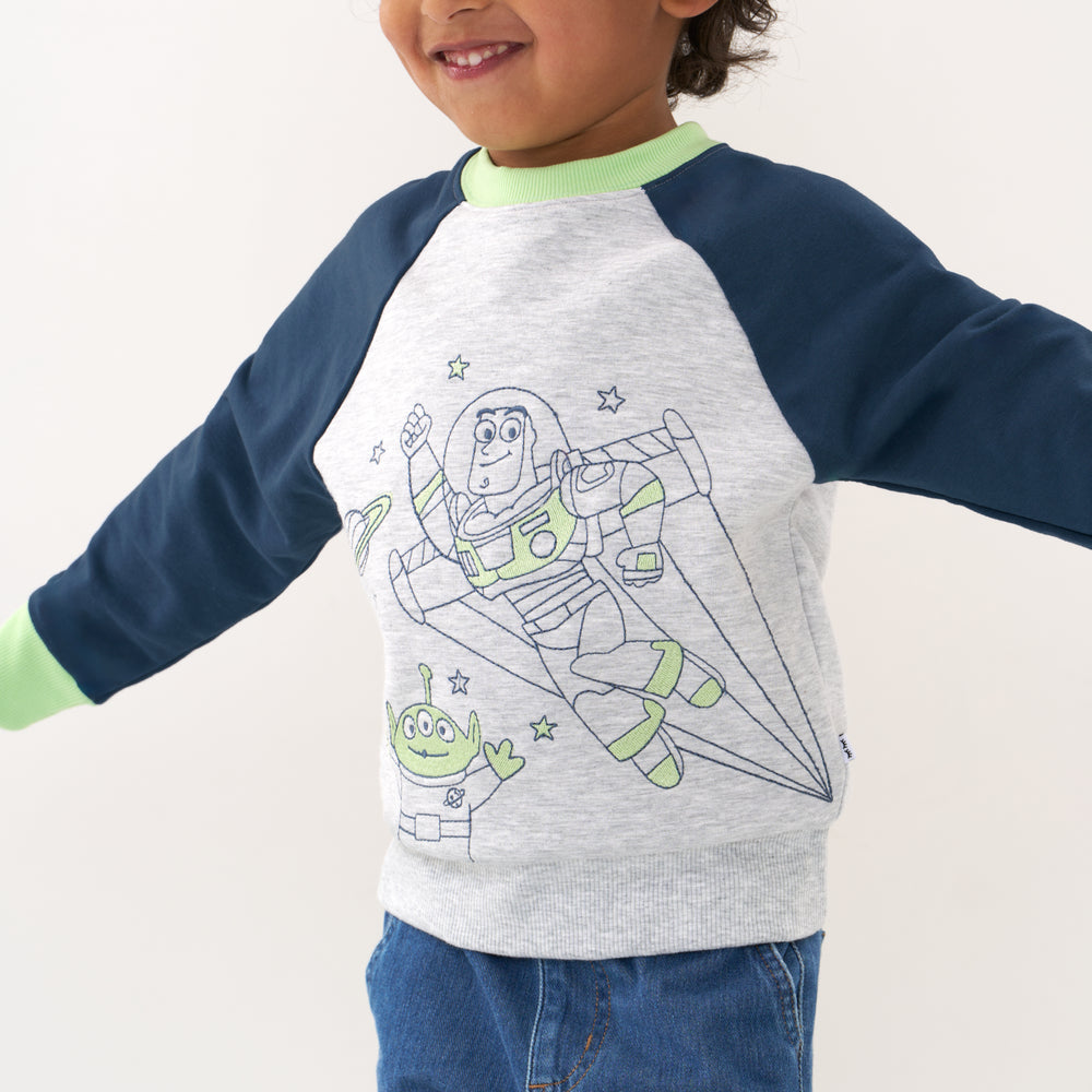 Click to see full screen - Close up image of a child wearing a Disney Pixar Buzz Lightyear crewneck sweatshirt