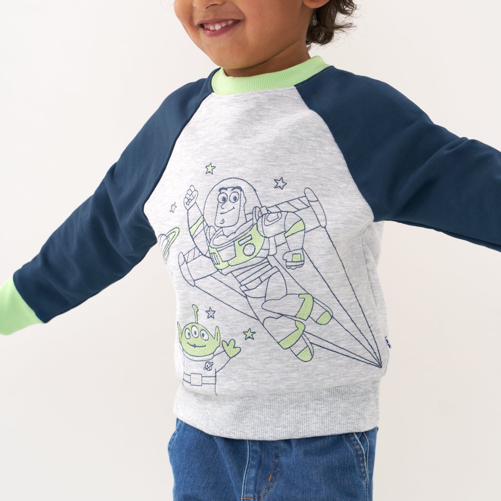 Close up image of a child wearing a Disney Pixar Buzz Lightyear crewneck sweatshirt