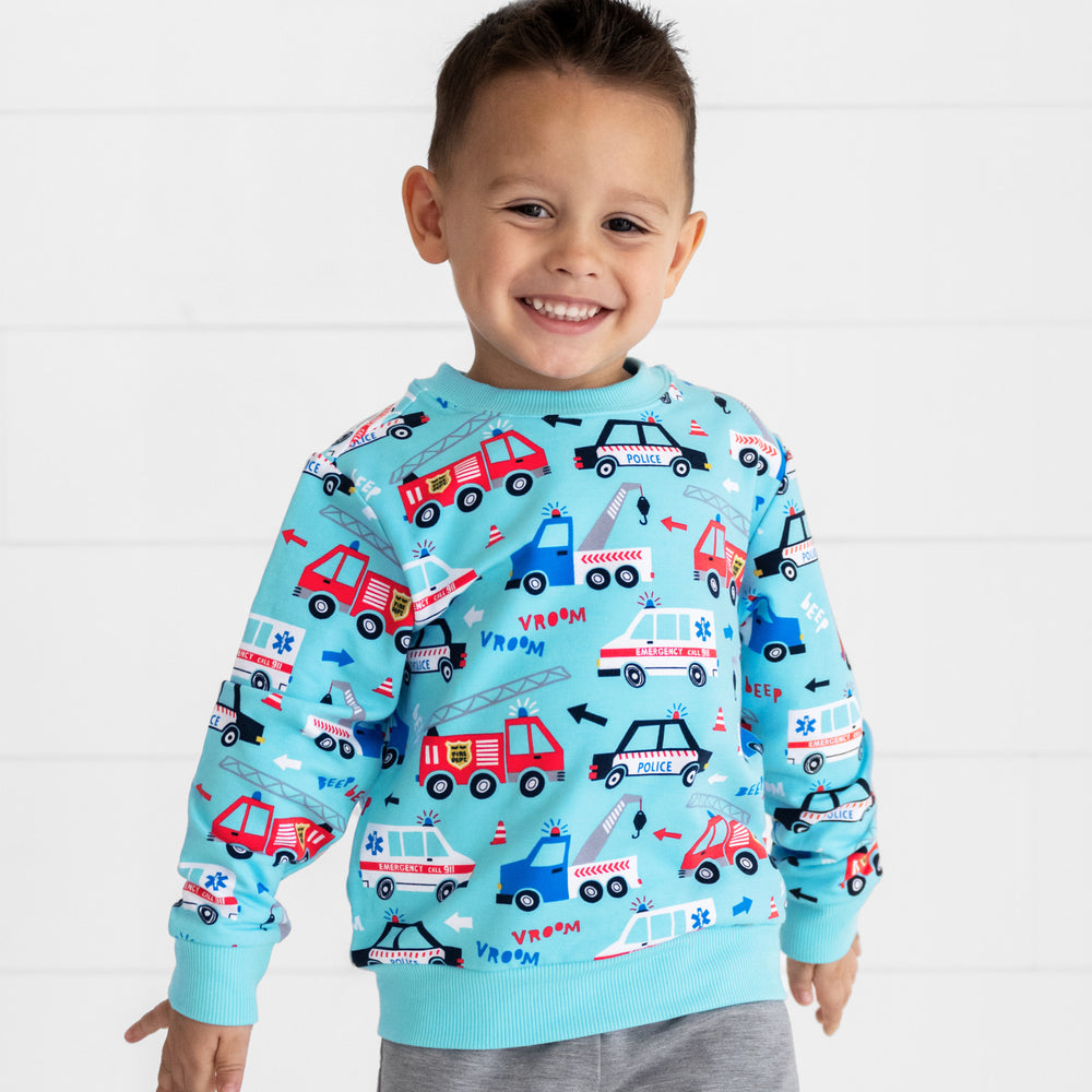 Smiling boy wearing the To The Rescue Crewneck Sweatshirt