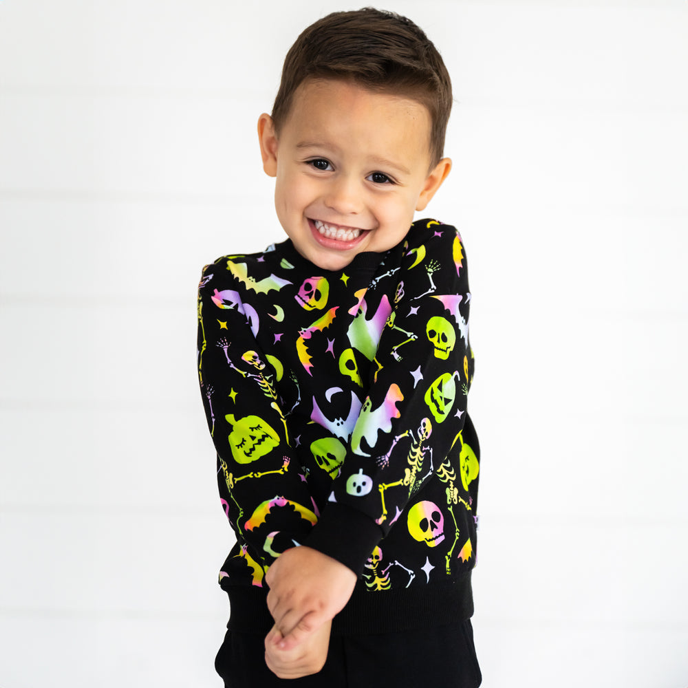 Close up image of a child wearing a Cool Ghouls Crewneck Sweatshirt and Black Jogger