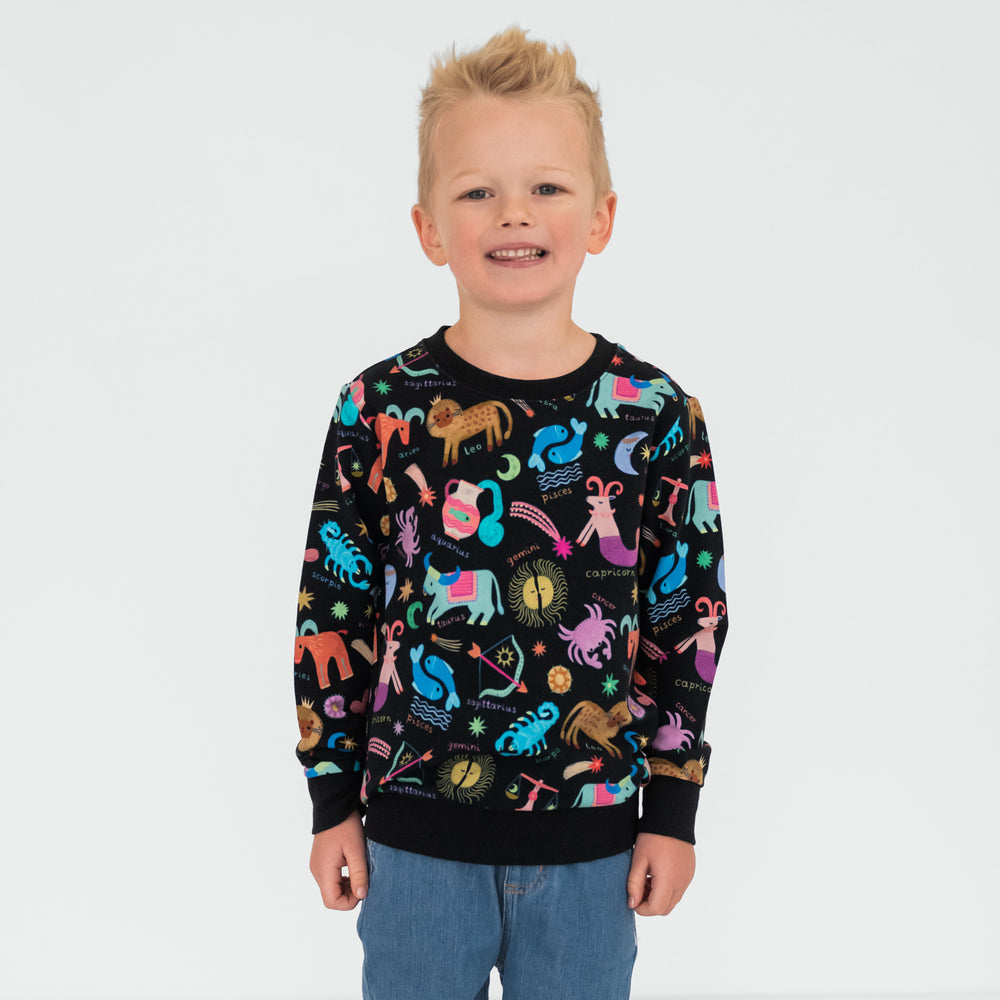 child wearing a star signs crewneck sweatshirt and midwash blue denim jogger