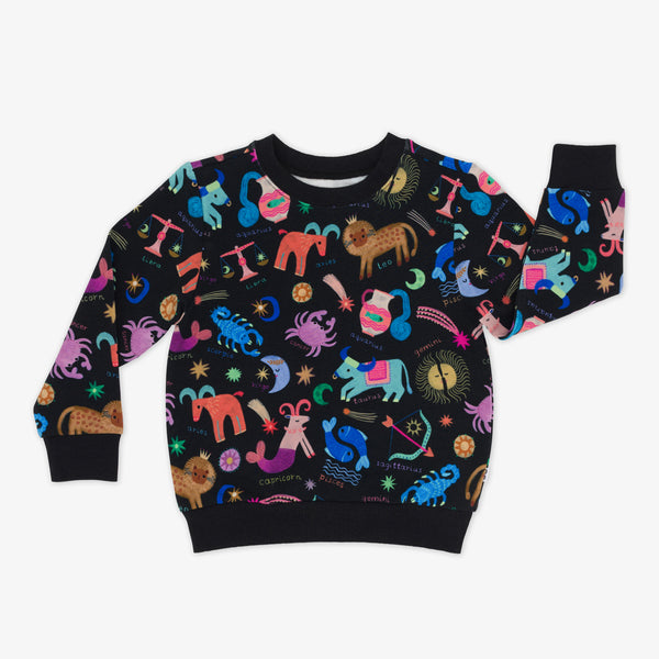 flat lay of a star signs crewneck sweatshirt featuring multicolored drawings of the zodiac signs on a black background