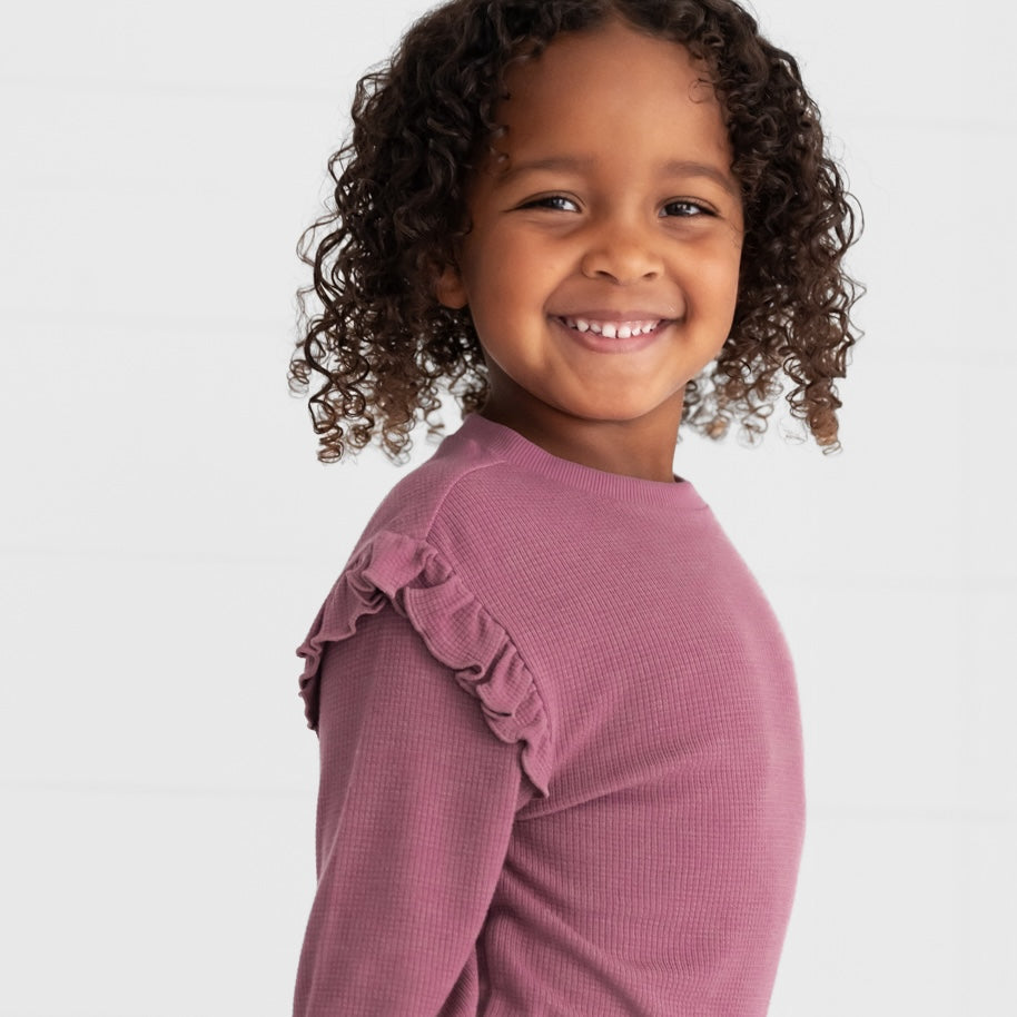 Close up image of a child wearing a Dusty Plum Waffle Flutter Crewneck