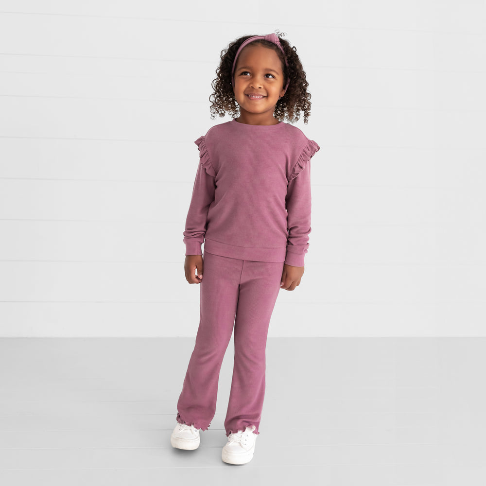 Image of a child wearing a Dusty Plum Waffle Flutter Crewneck, Waffle Flare Pant, and Waffle Knotted Headband