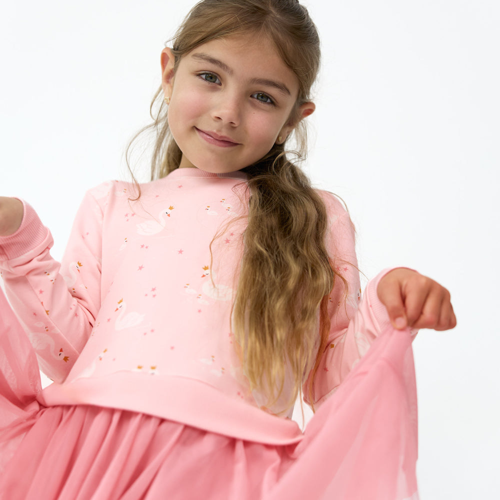 Close up image of girl smiling while posing with the tutu on the Rosy Swan Crewneck Tutu Dress