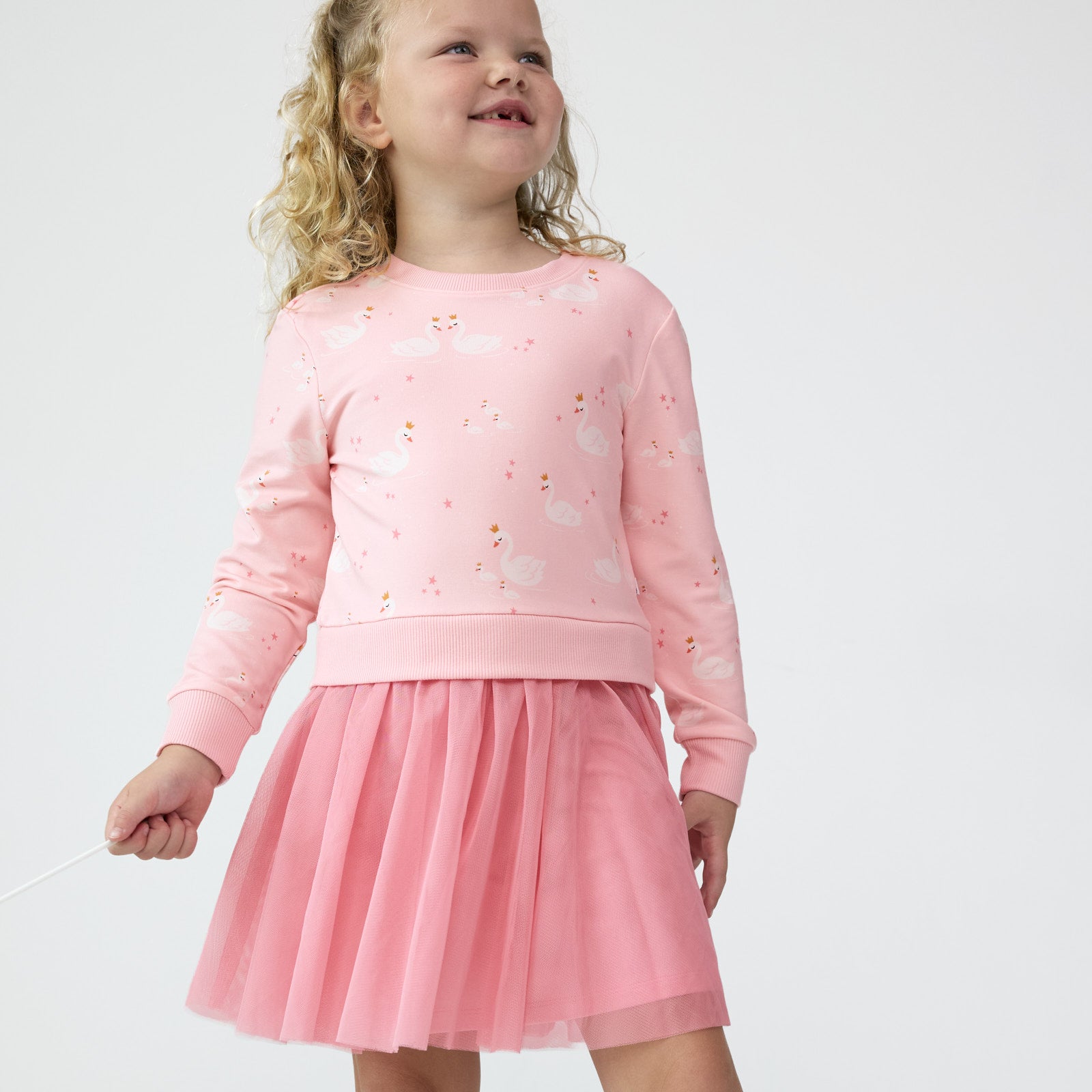 Girl smiling and posing while wearing the Rosy Swan Crewneck Tutu Dress