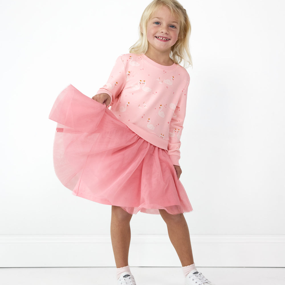 Smiling girl posing in the Rosy Swan Crewneck Tutu Dress while dislaying the tut detail on the dress