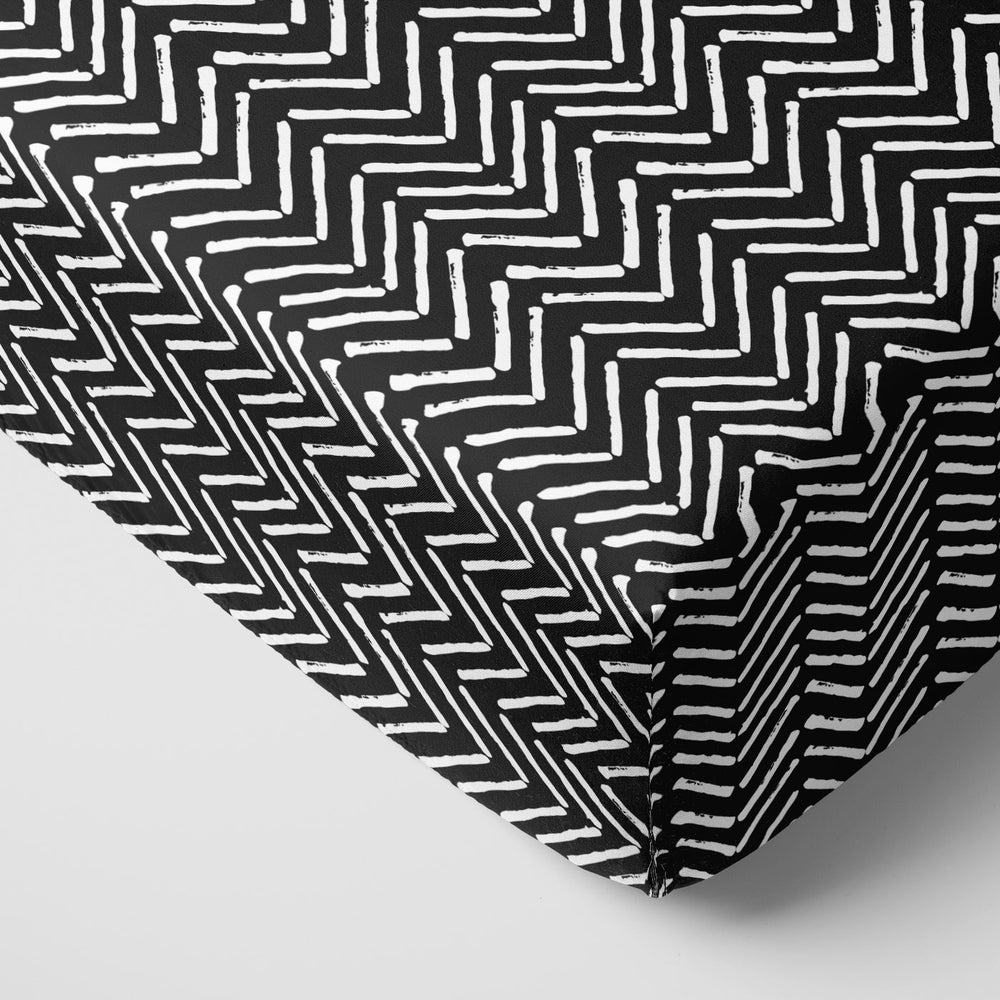 Close up image of a Monochrome Chevron fitted crib sheet on a mattress