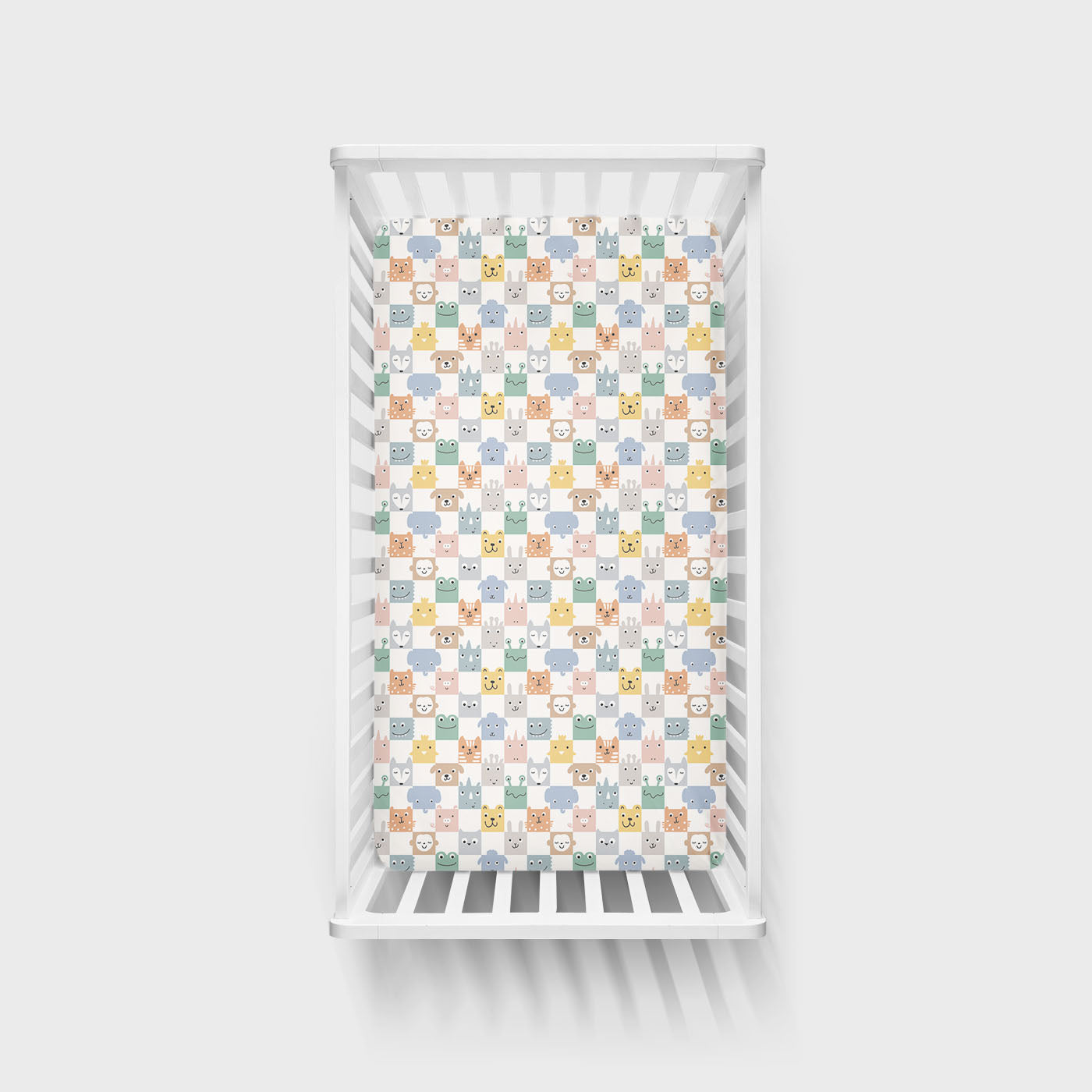 Overhead view image of a Check Mates Fitted Crib Sheet on a mattress in a crib
