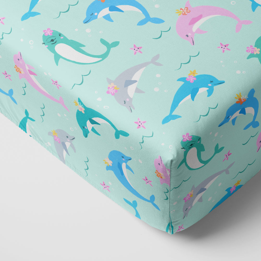 Close up image of a Dolphin Dance fitted crib sheet on a mattress