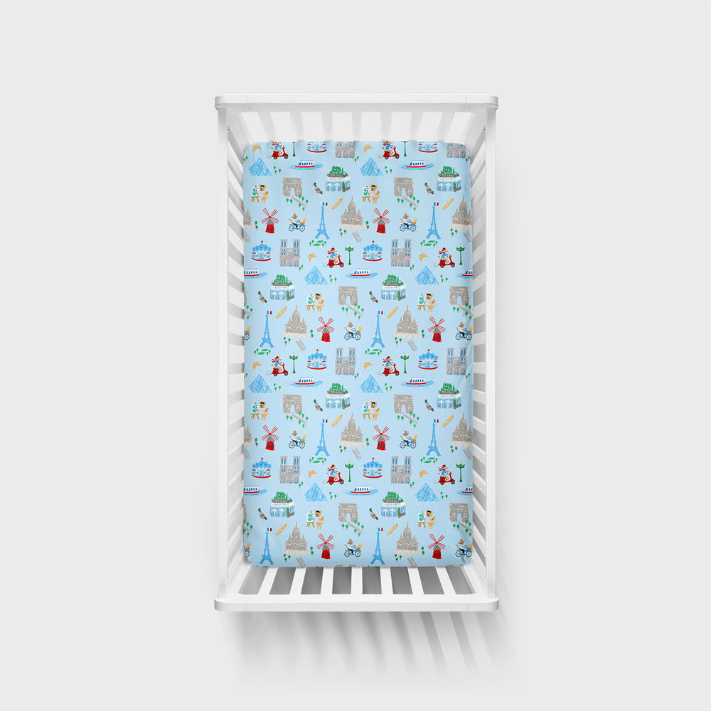 Top view image of the Blue Weekend in Paris Fitted Crib Sheet in a white crib