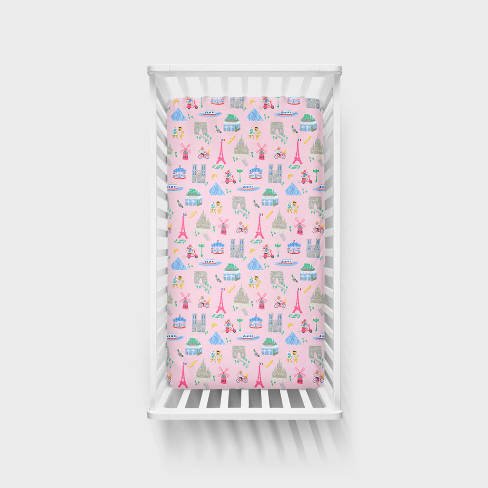 Top view image of the Pink Weekend in Paris Fitted Crib Sheet in a white crib