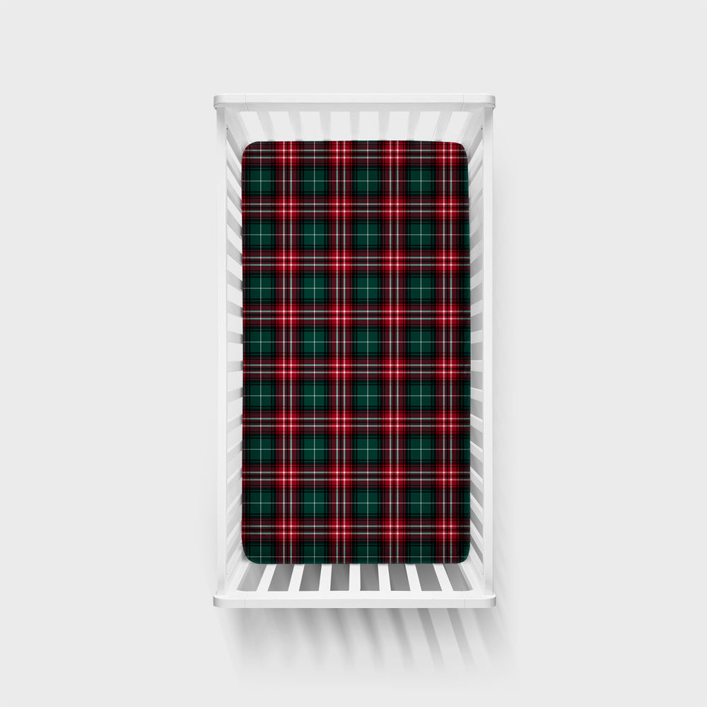 Overhead image of a Fireside Plaid Fitted Crib Sheet on a mattress in a white crib