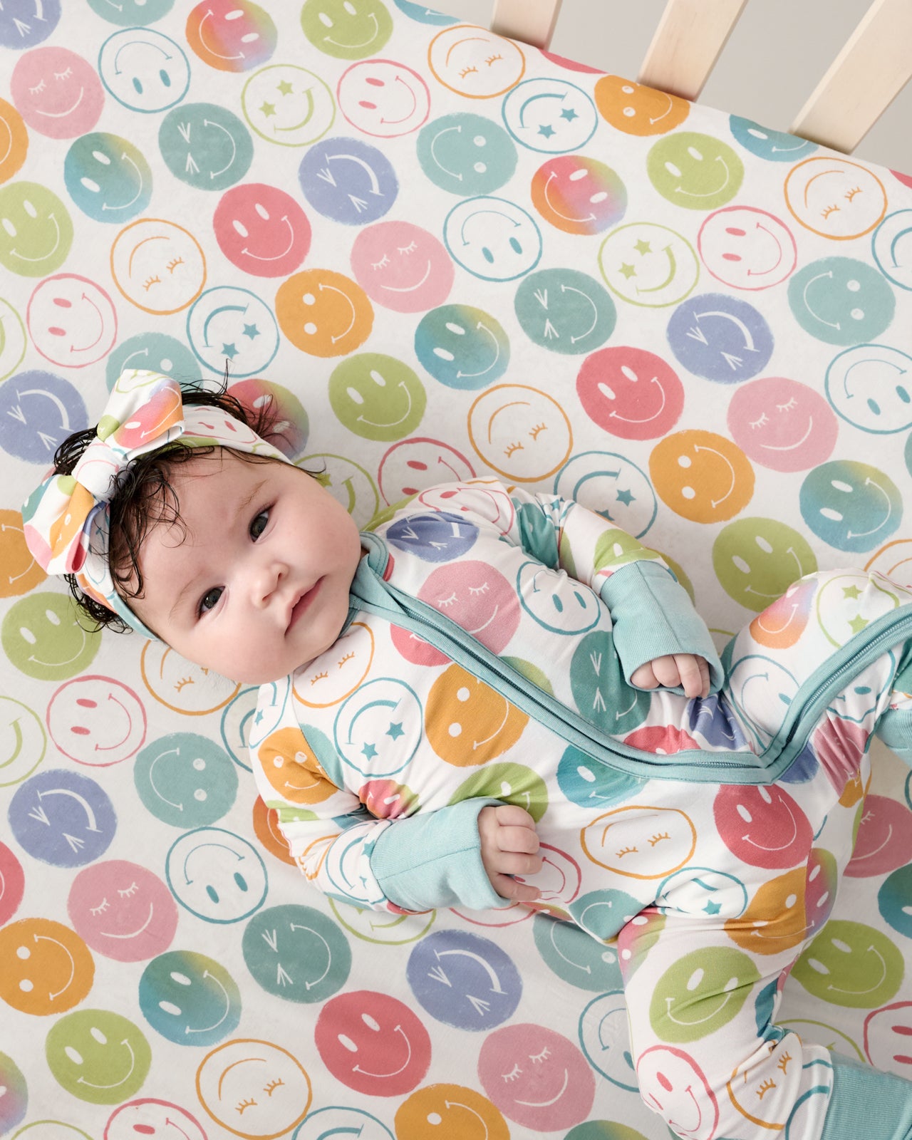 Overhead view of baby laying on the Positive Vibes Fitted Crib Sheet