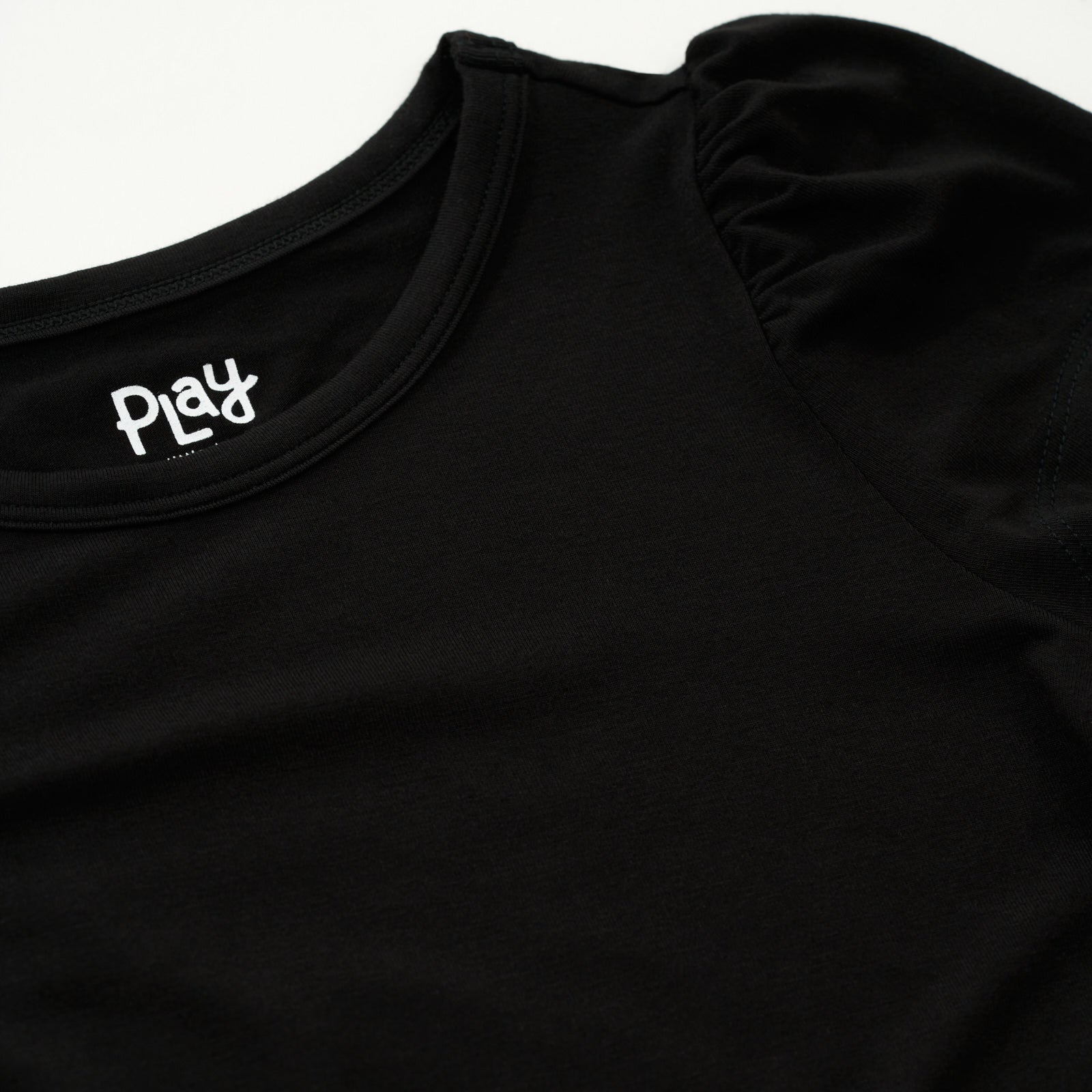 Close up flat lay image of the shoulder detail on the Black Puff Sleeve Tee