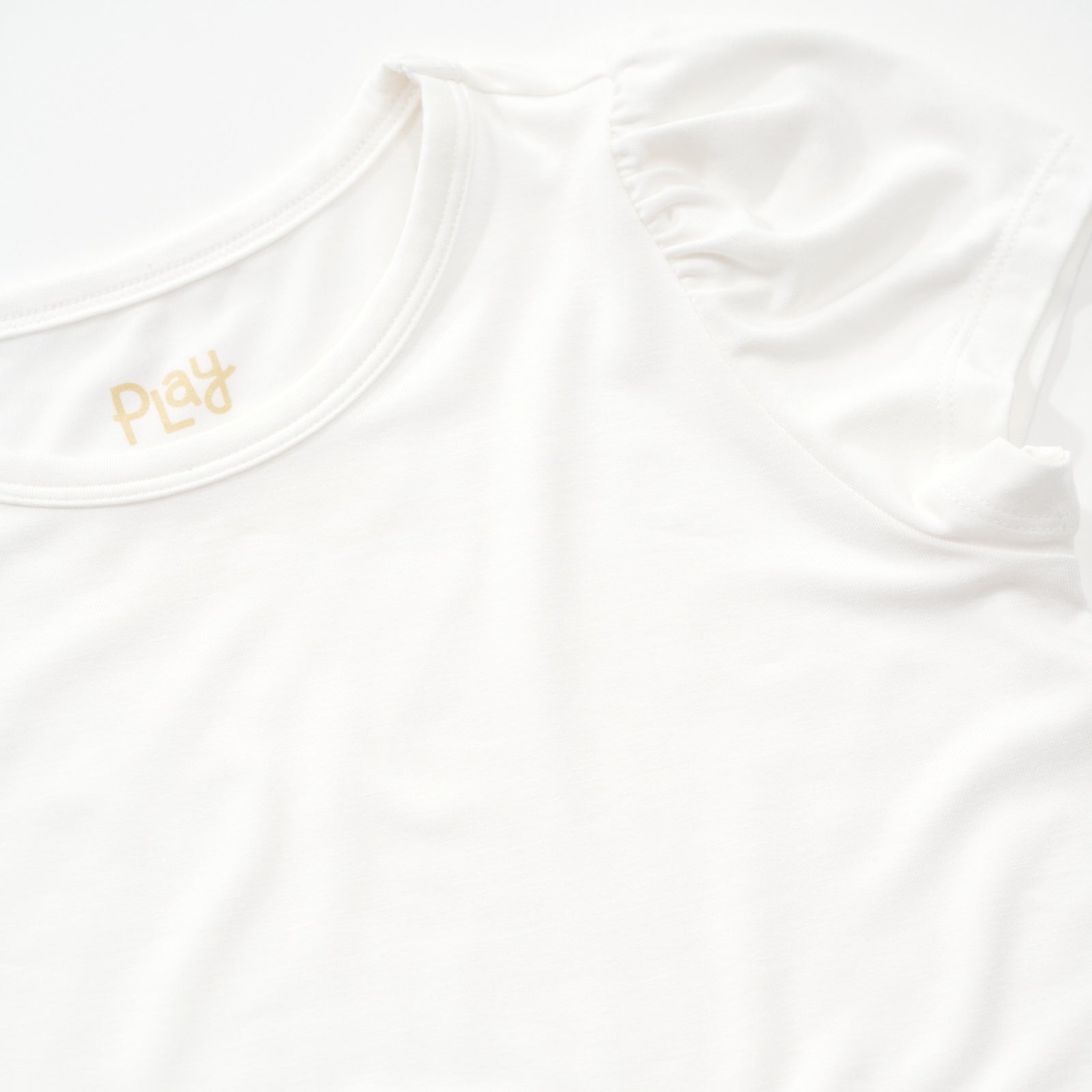 Close up image of the puff sleeve on a Soft white puff sleeve tee