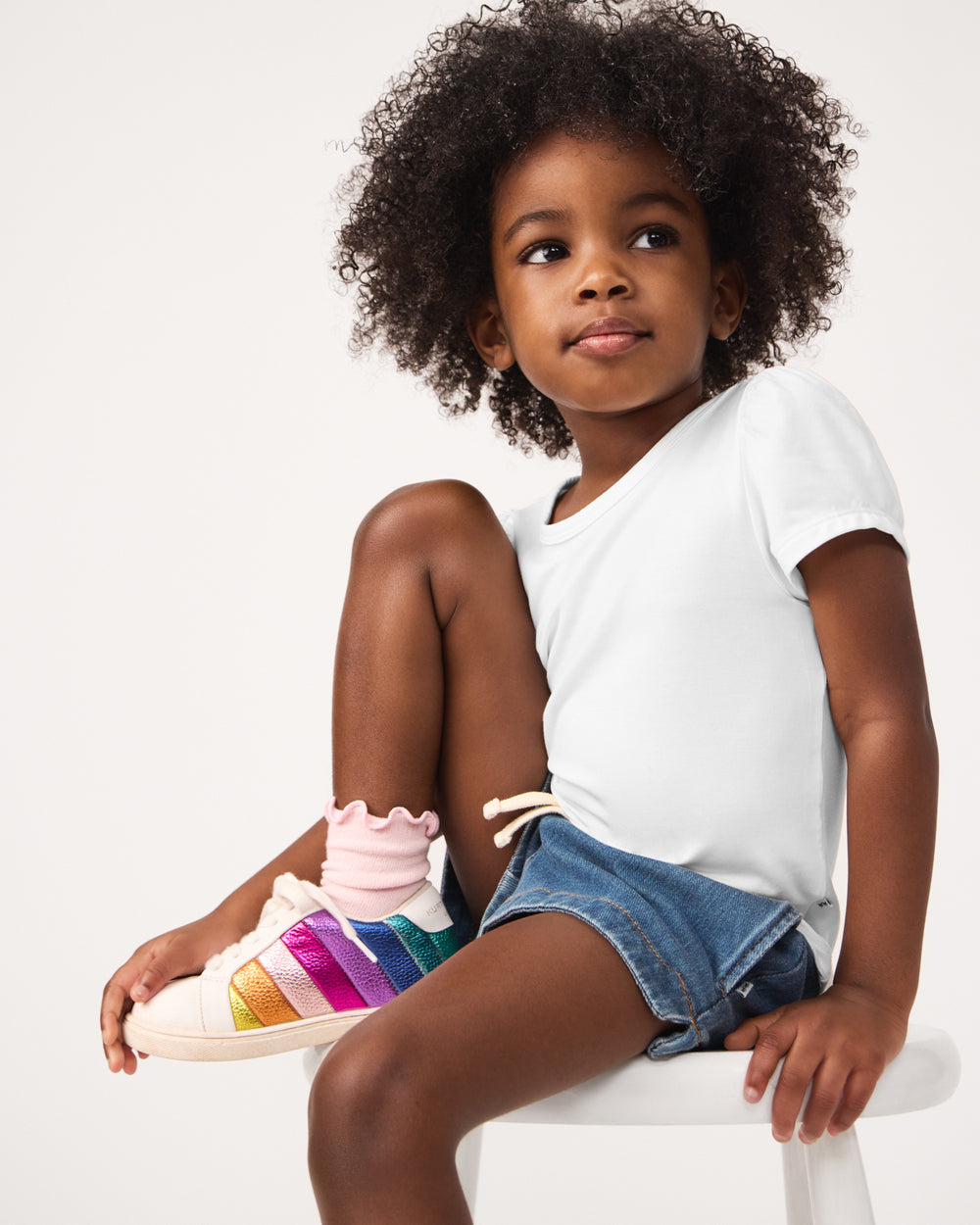 Close up of girl wearing the Soft White Puff Sleeve Tee with rainbow sneakers