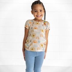 Image of a child wearing a Desert Sunrise Puff Sleeve Tee and Light Blue Denim Jegging