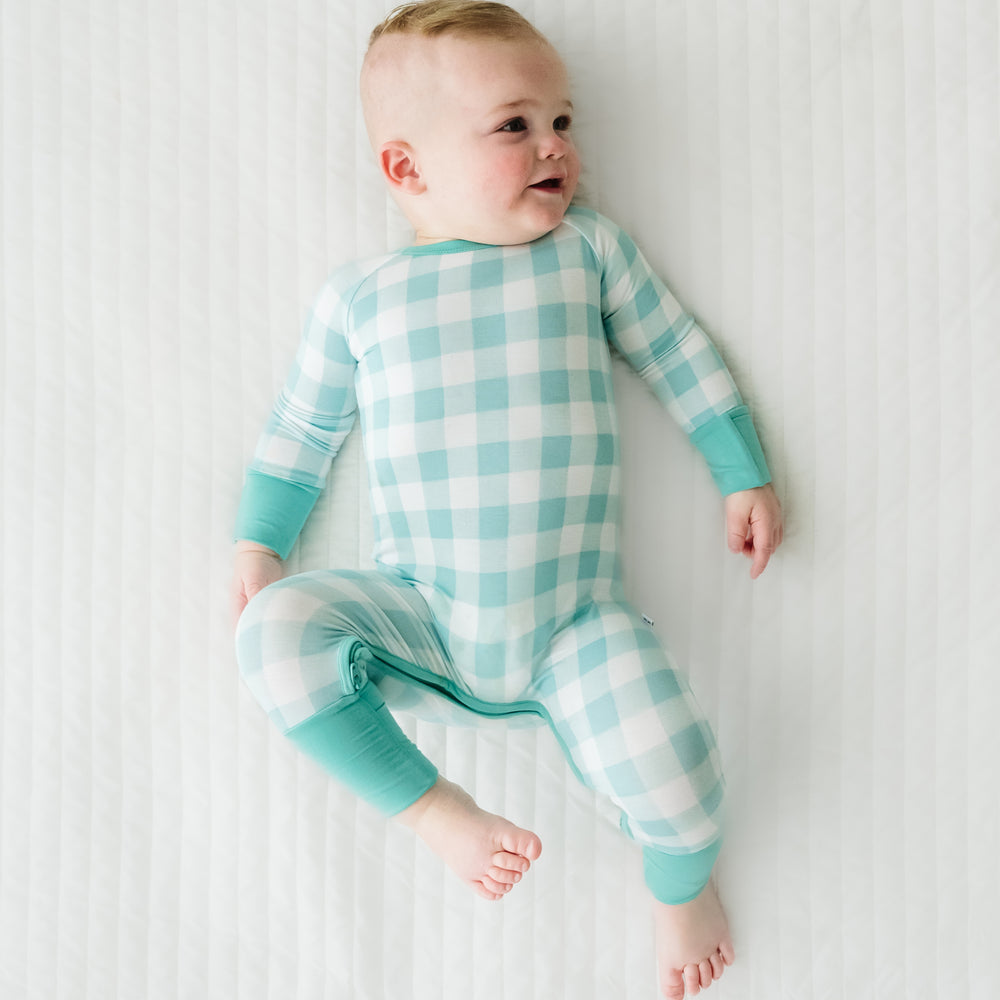 Click to see full screen - Alternate image of a child laying on a bed wearing a Aqua Gingham crescent zippy