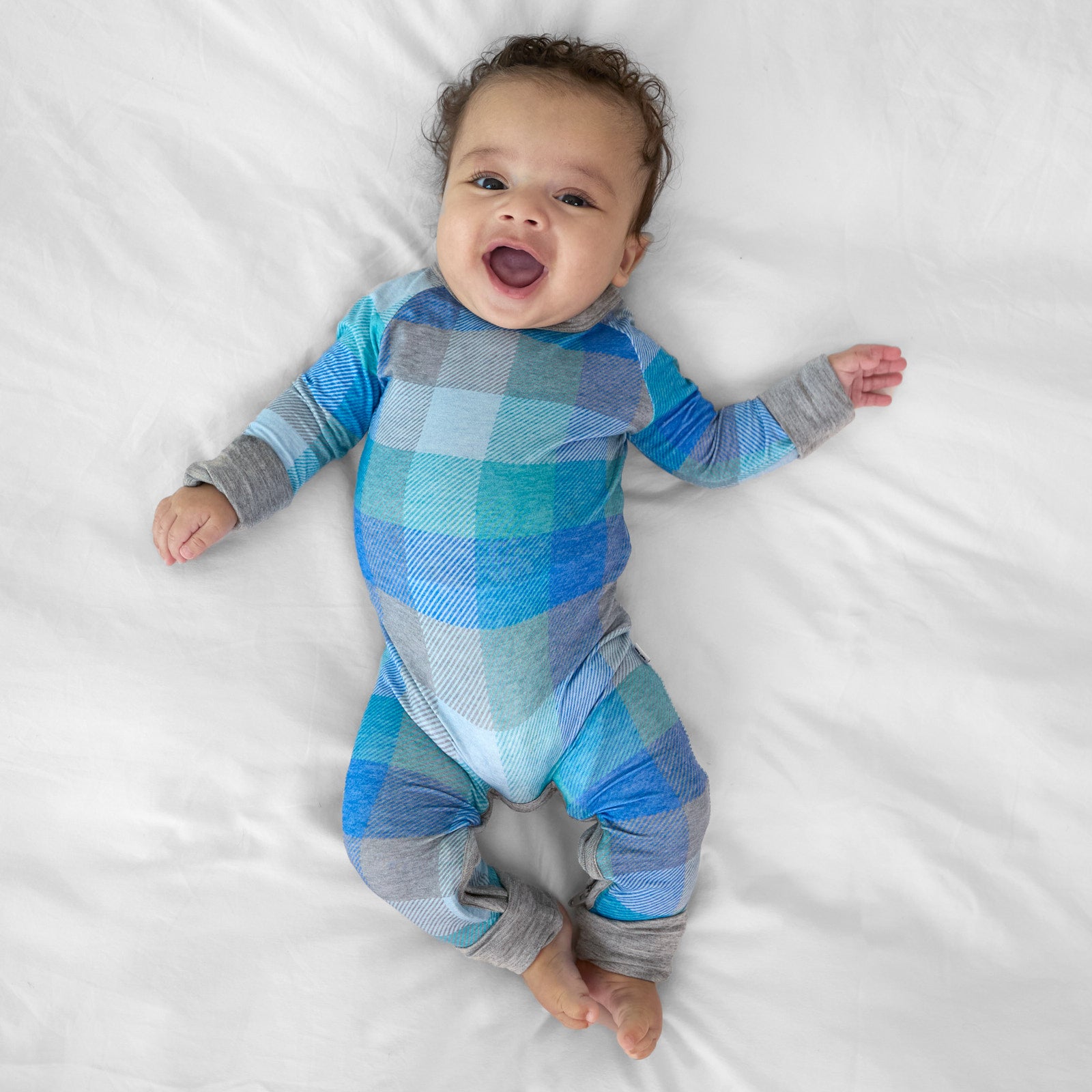 Alternate image of a child laying on a bed wearing an Arctic Plaid crescent zippy