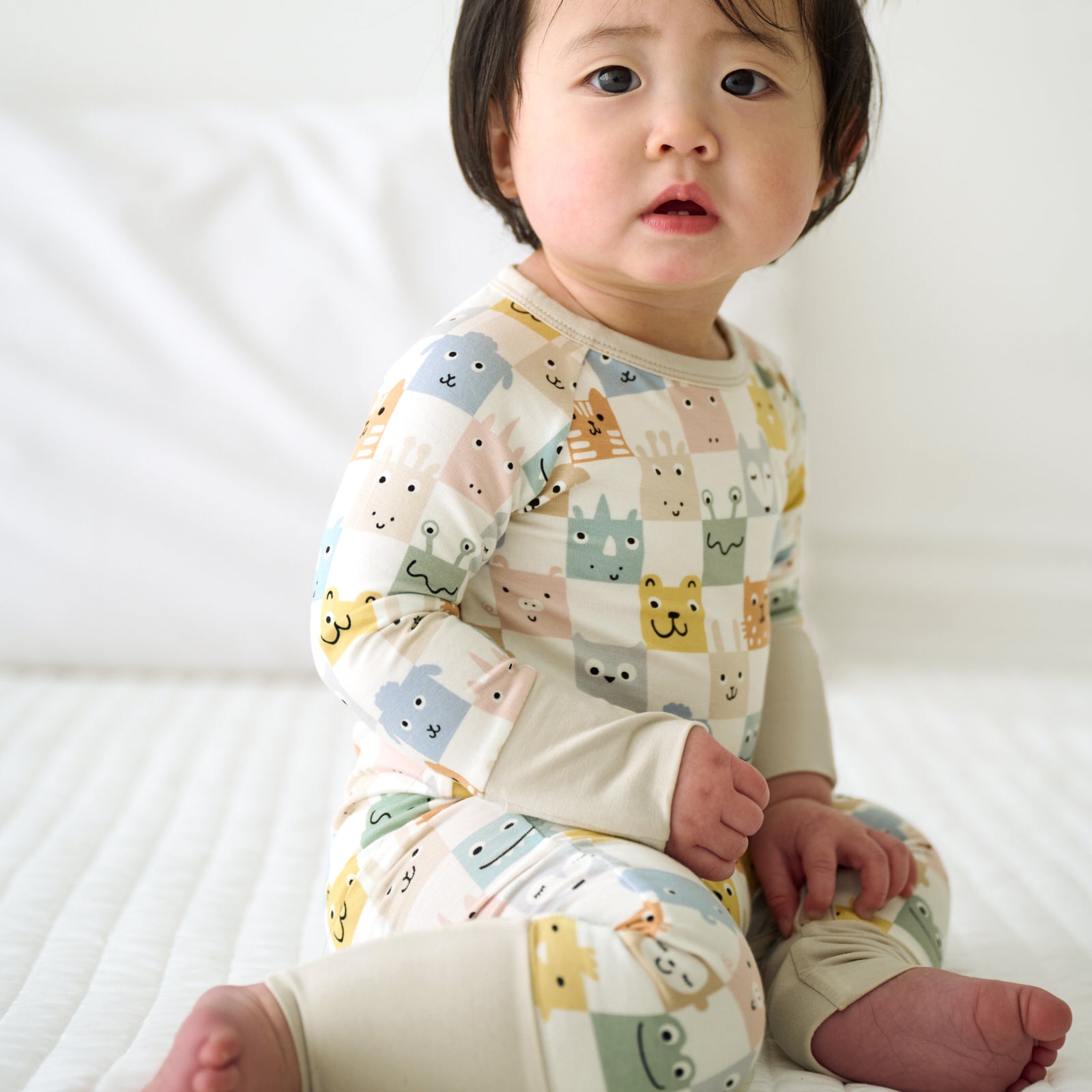 Child sitting on the ground wearing a Check Mates Crescent Zippy