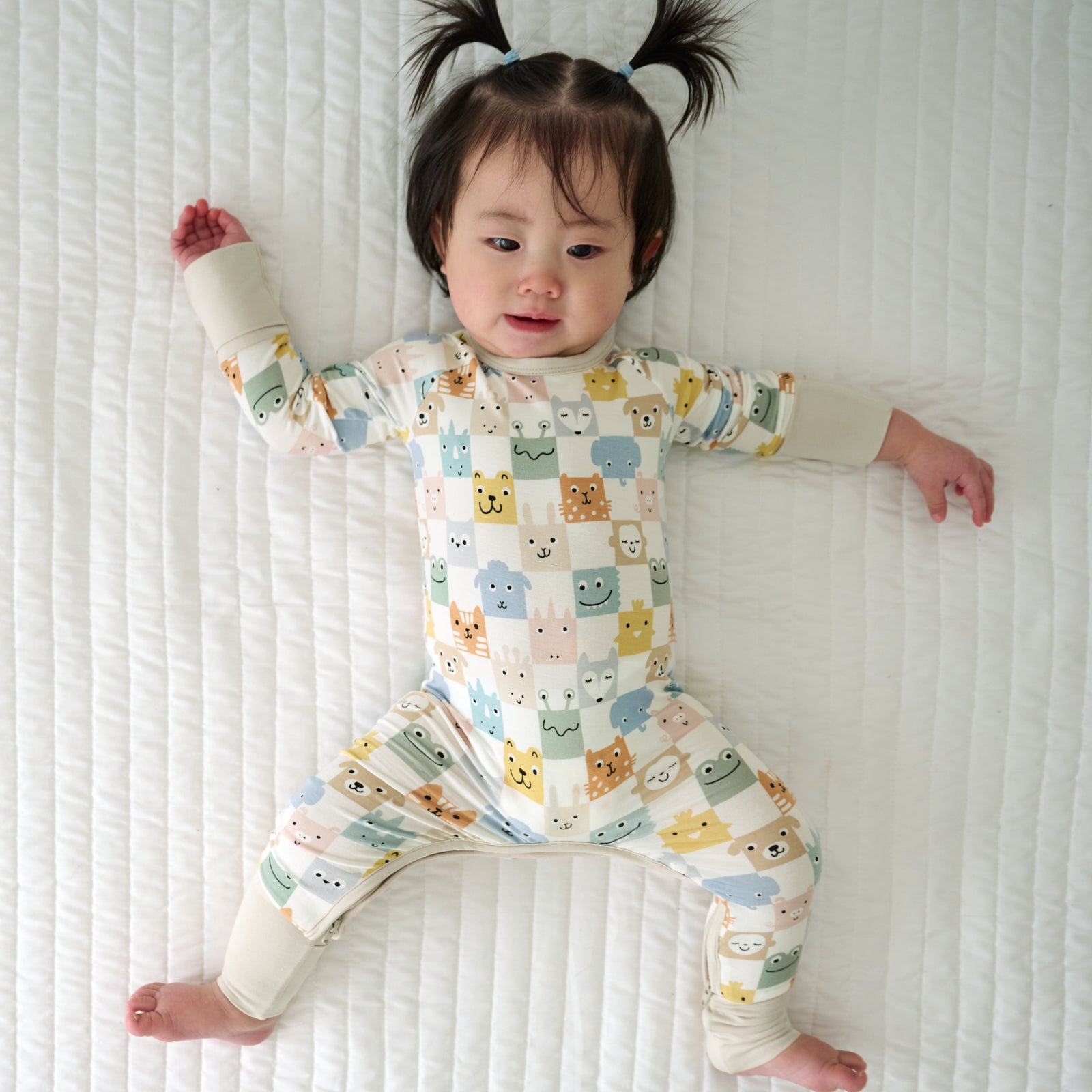 Child laying on a blanket wearing a Check Mates Crescent Zippy