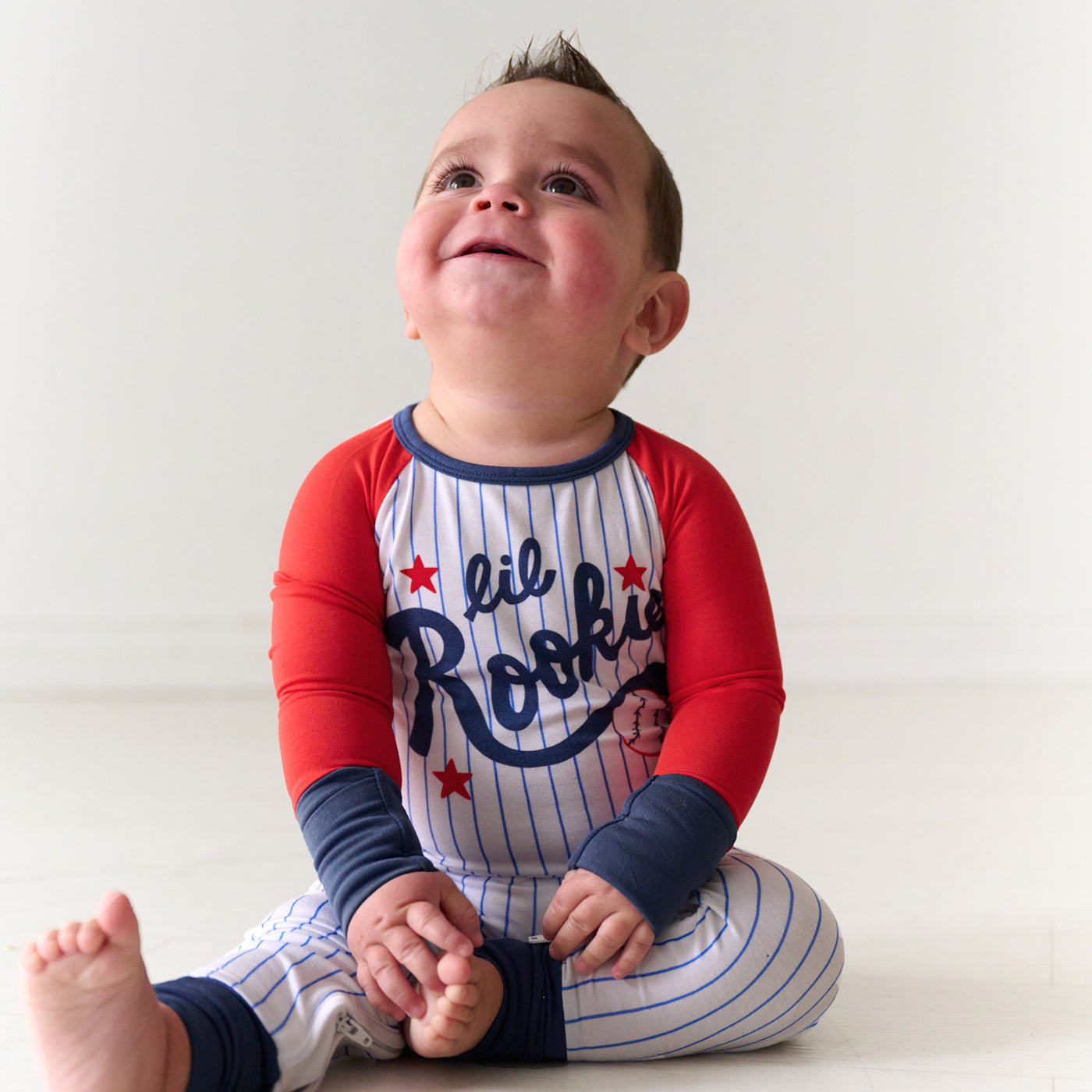 Child sitting wearing a Blue Little Rookie Crescent zippy