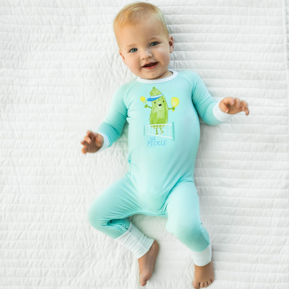 Baby laying down while wearing the Pickle Power Crescent Zippy