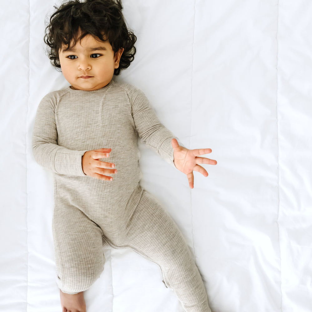 Alternate image of a child laying on a bed wearing a Heather Stone Ribbed crescent zippy