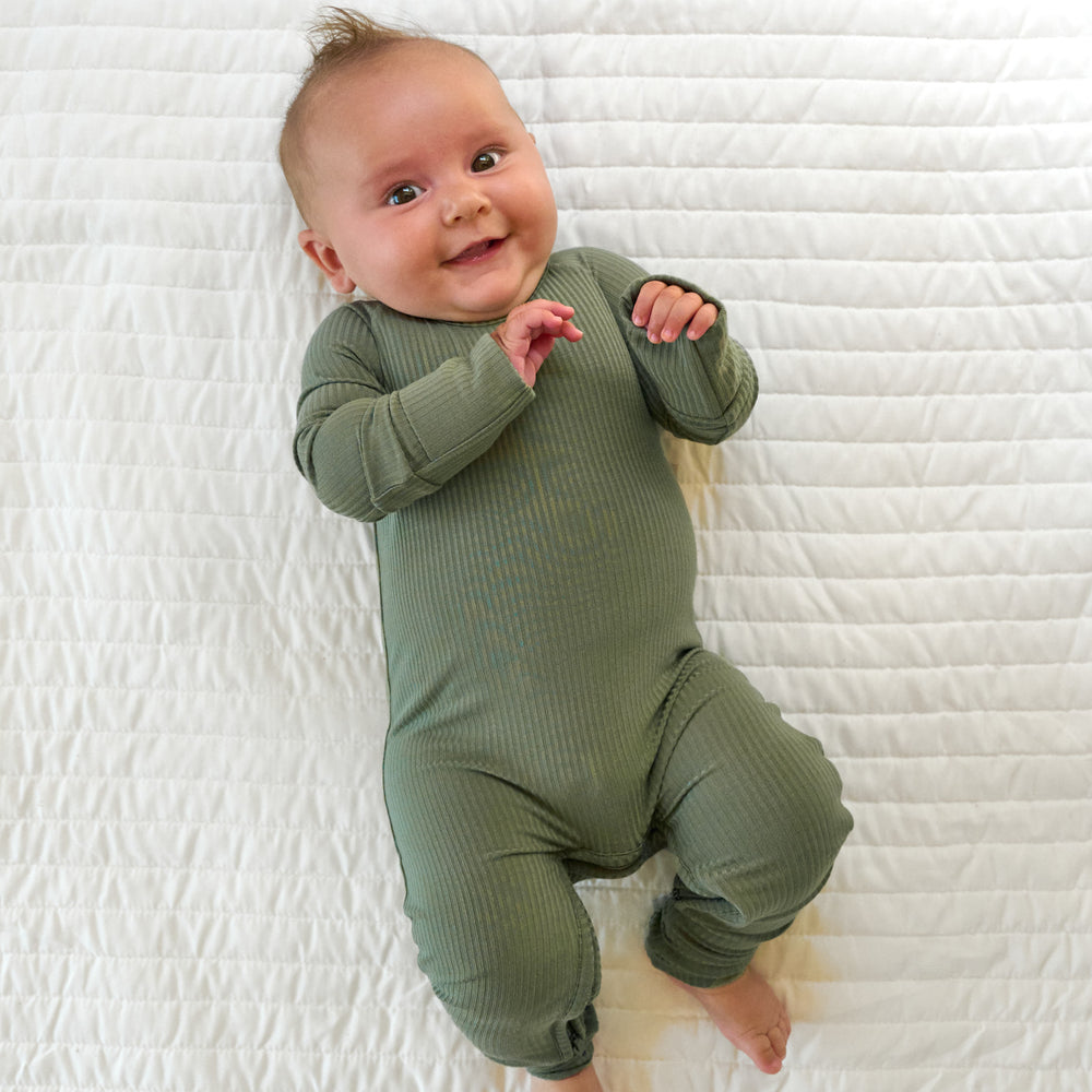 Top view image of baby laying down while in the Moss Ribbed Crescent Zippy