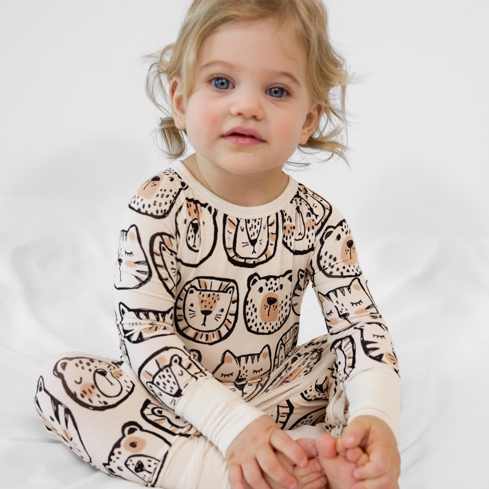 Child sitting wearing a Lions, Tigers, and Bear crescent zippy