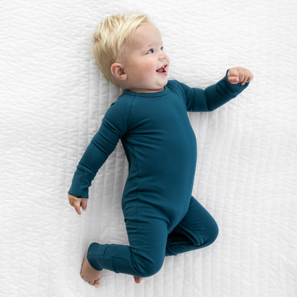 alternate image of a child laying on a bed wearing a Cozy Twilight Teal crescent zippy