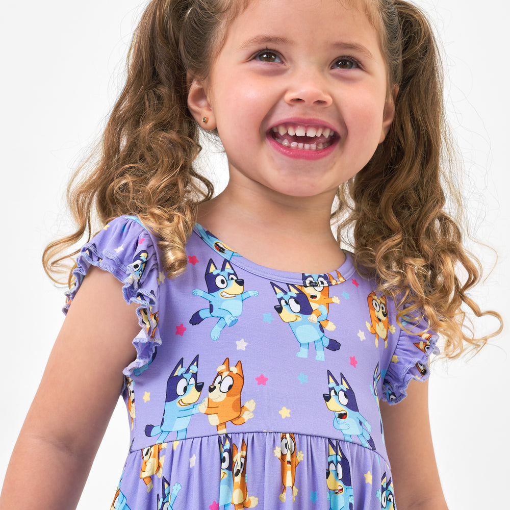 Close up image of a child wearing a Bluey flutter twirl dress